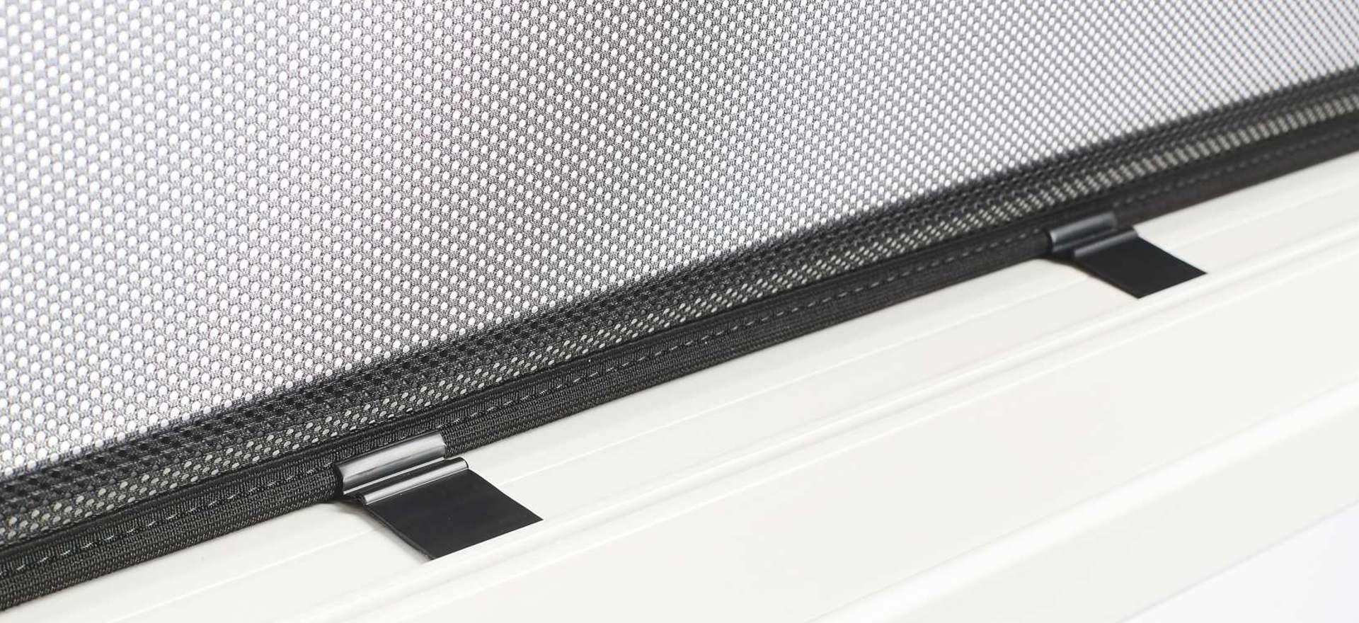 Textilscreen als Sonnenschutz ein Detailbild eines Fenster Sonnenschutzes mit zwei Haltern
